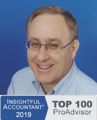 Photograph of Keith Gormezano, famous Advanced Certified QuickBooks ProAdvisor&reg; and QuickBooks Consultant, Trainer, Tutor, Instructor, Coach, or Teacher for new businesses and start ups in Seattle, Washington State who offers personalized, in person, one-on-one help, support, classes and training or clean up or set up assistance at your place, his, a quiet coffee shop, library, or other place with secure WiFi, or online using the phone and/or Instant Messenging (IM) wearing a pale blue button down business formal Nordstrom's shirt made of soft 100% cotton, short slightly receding light brown hair with a touch of gray showing his wisdom, blue eyes, trendy horizontal glasses with TransitionsB. photochromic lenses and flexible titaniam frames from Greenwood Optical, two behind the ear (BTE) CantuB 780D hearing aids from The Hear Center since replaced by two Phonak Savia Arts with Bluetooth receivers from the Veteran's Administration for free for his service so he can use them with his new cell phone with the company's SmartLink BlueTooth bridge and directional microphone device in noisy settings, and his always present smile and patience.